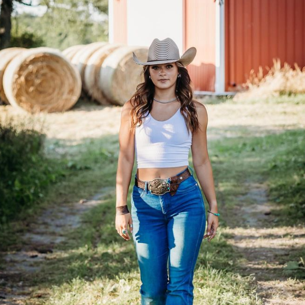 Woman with pole bending rodeo belt buckle